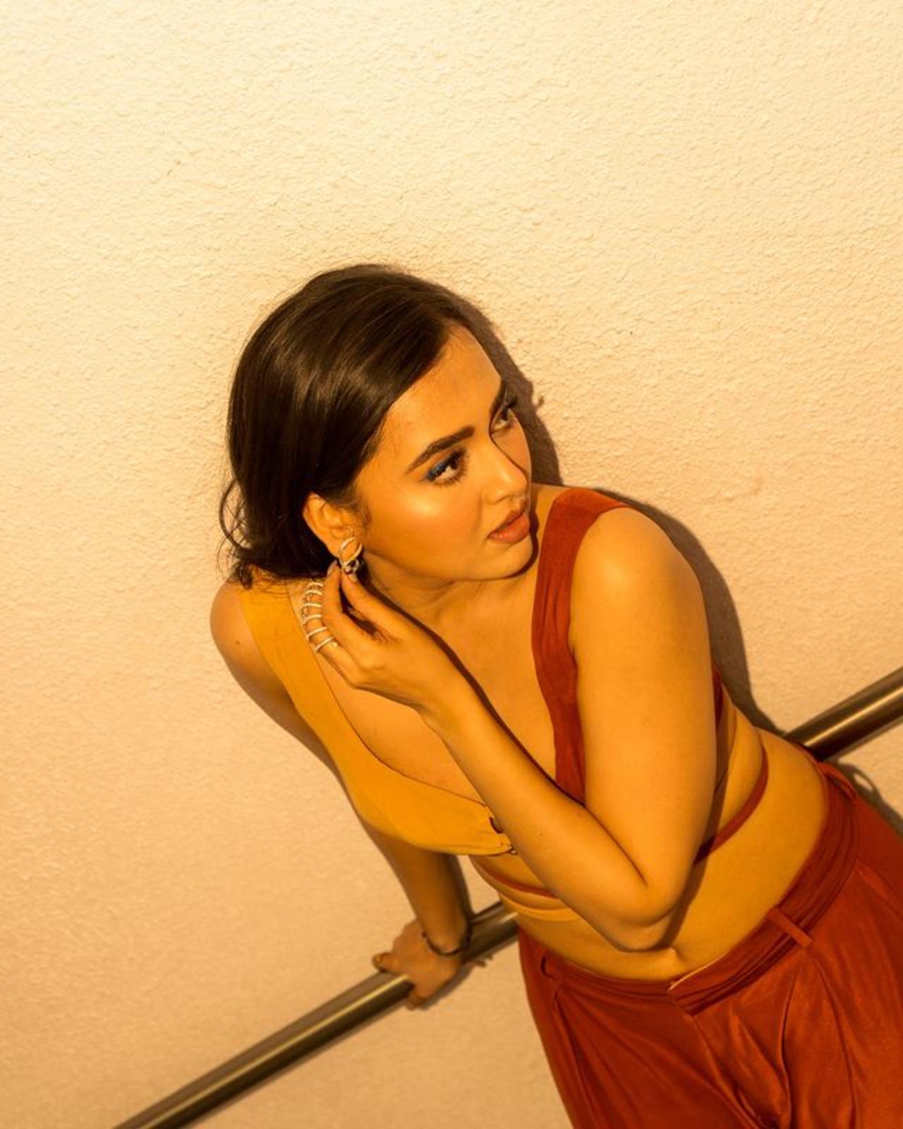 Tejasswi for her this look decided to do something interesting as she paired brown pants with a cream and brown crop top