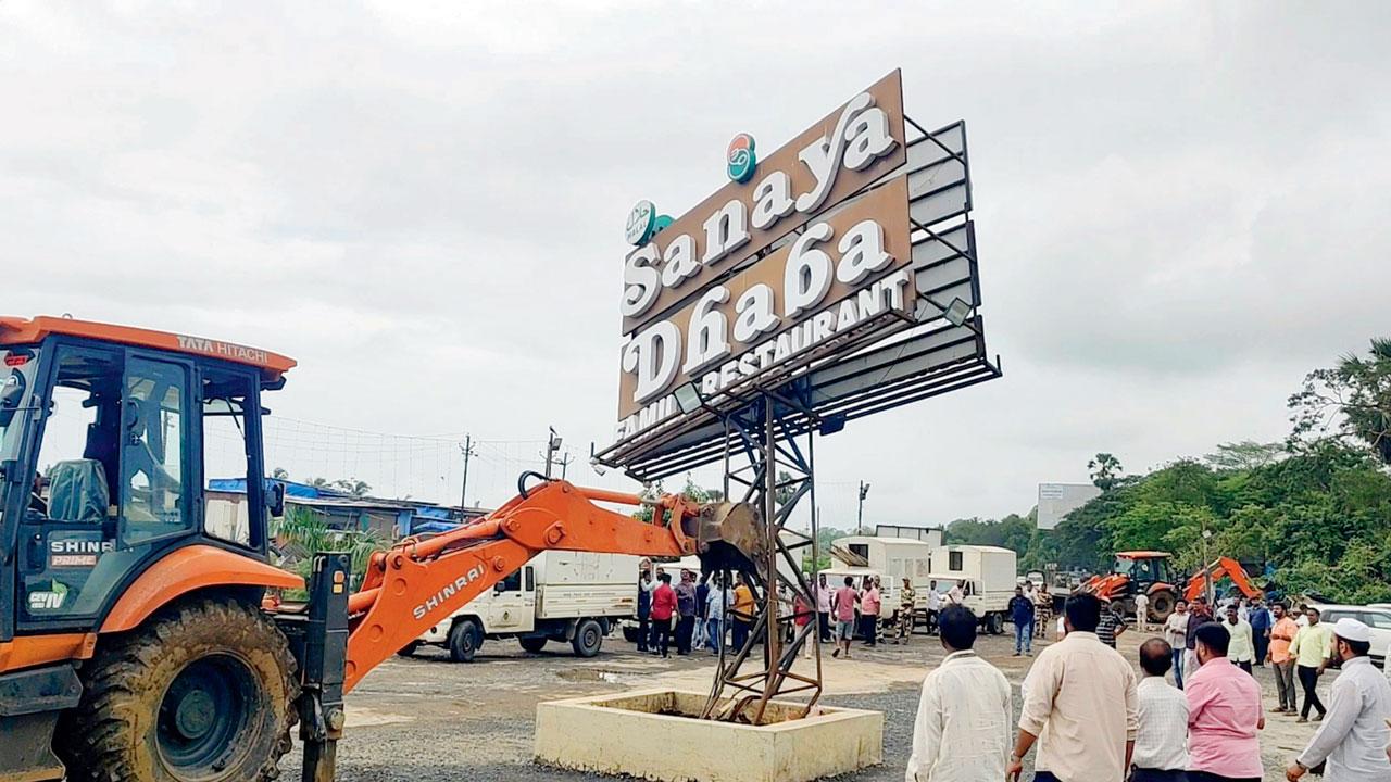 Workers demolish illegal dhabas and stalls along the Mumbai-Ahmedabad Highway near Sasunavghar in Vasai East, on Tuesday