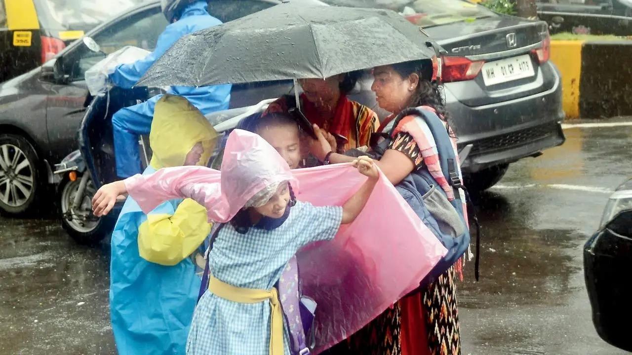 Caught in a sudden shower, children get under umbrellas, at Fort, on Friday. Pics/Sayyed Sameer Abedi
 