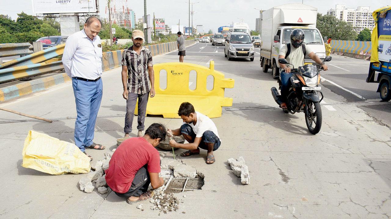 Workers repair the damaged portion of the bridge on Monday. Pics/Sameer Markande