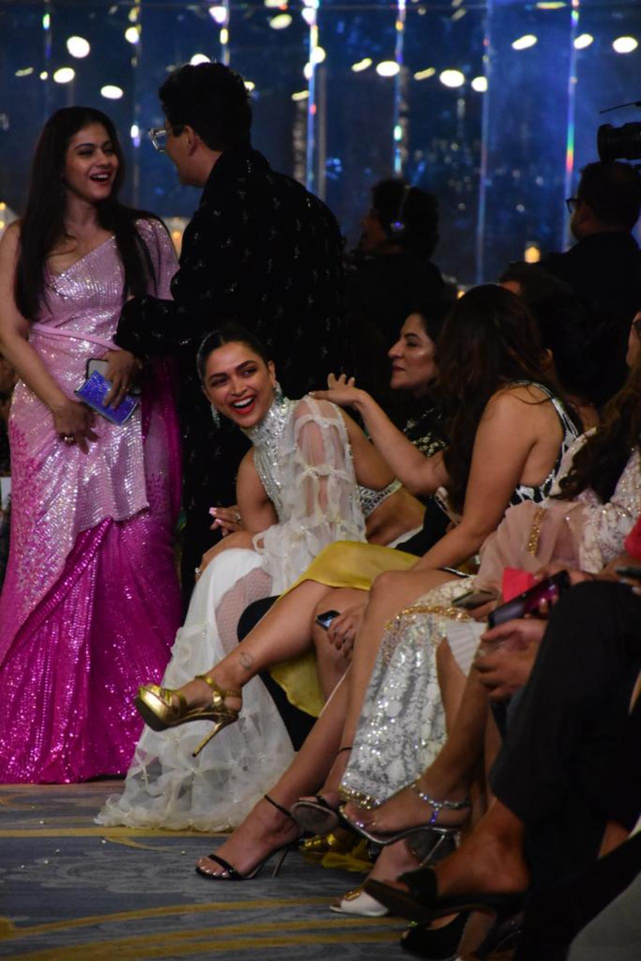 Deepika Padukone caught in a candid moment as she engages in fun banter with the other guests. Karan Johar and Kajol can also be seen in the background
