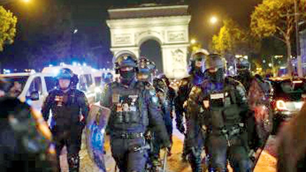 Police officers with batons and shields patrolling Paris. Pic/AP