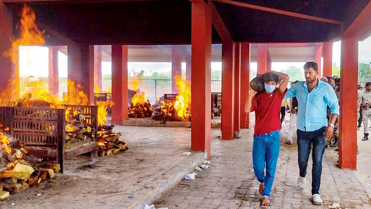 Relatives of those killed in the bus fire tragedy perform the ritual, as pyres burn at Vaikunth Smashanbhumi, in Buldhana, on Sunday. Pics/PTI