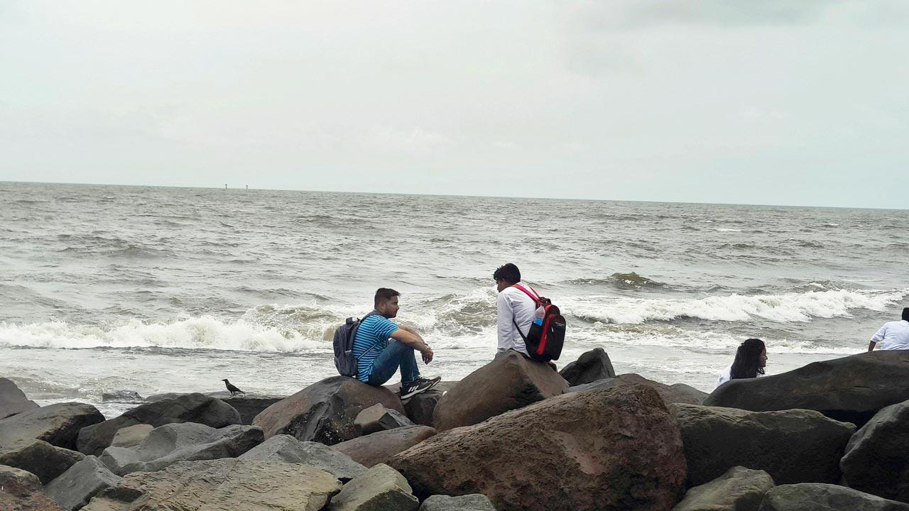 Visitors sitting along the shoreline at Bandra Bandstand on Thursday. Pics/Ashish Raje