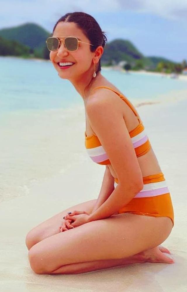 Anushka rocks a chic and modest look in her stunning high-waisted orange and white bikini. Pure beach elegance!    