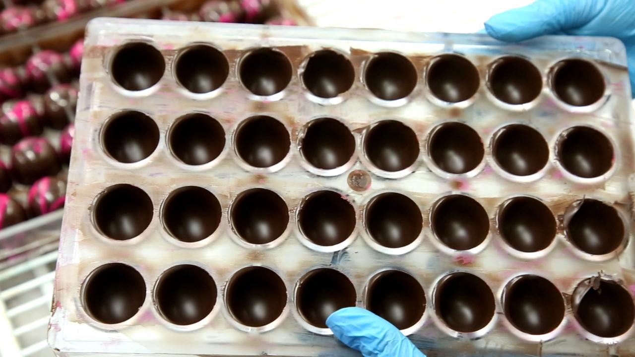 Post the method of tempering chocolate, the melted liquid is poured into shells. It is left to settle for a while to take the shape of the outer Bonbon cover