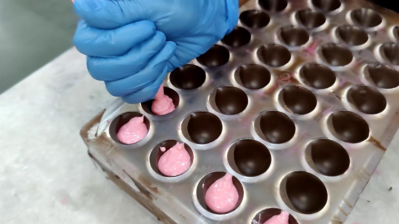 The next step is to fill the shells with the desired flavour. In this case, the chef uses a bubblegum flavour