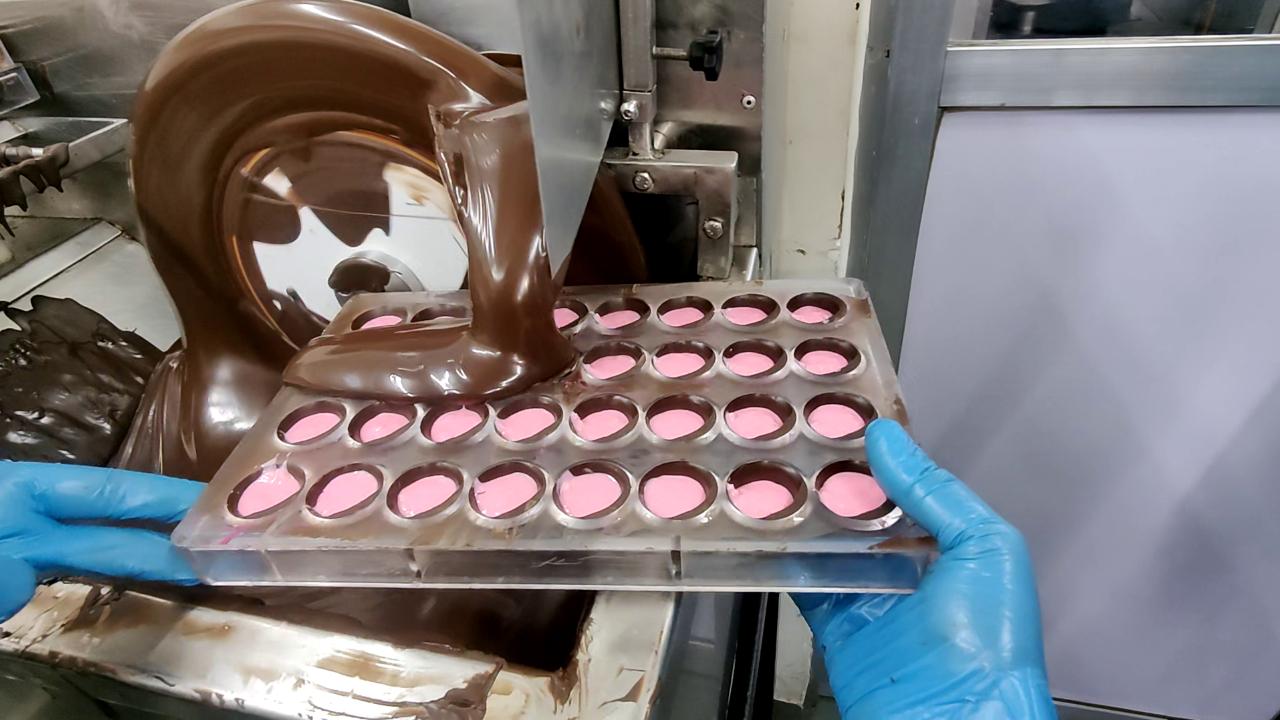After adding the filling, melted chocolate is poured on top and left to set