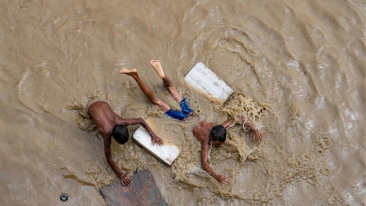 Children at play on a flooded road near the Red Fort as the swollen Yamuna river floods low-lying areas, in New Delhi
 