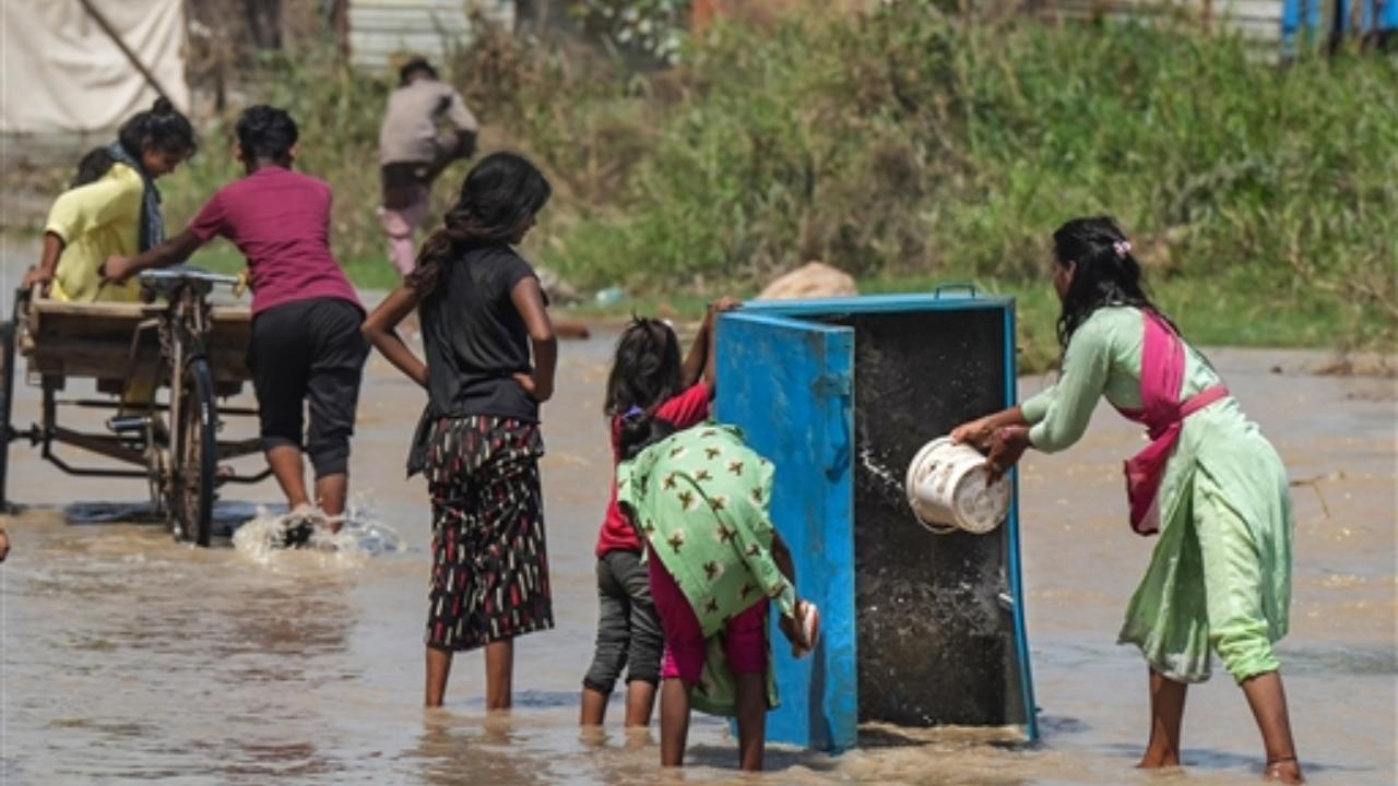 Locals wash a cabinet with water of the swollen Yamuna river near the Old Yamuna Bridge (Loha Pul)
 