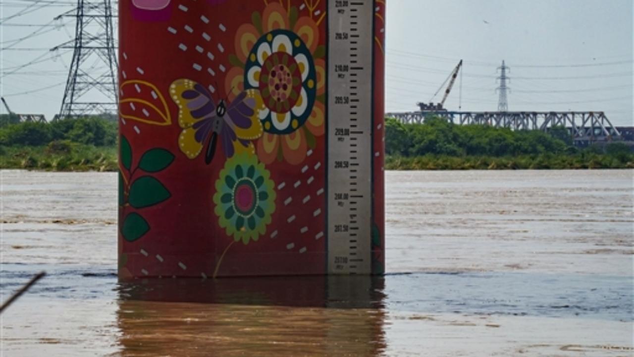 A water level marker at Yamuna river, in New Delhi, Monday, July 24, 2023. The Yamuna in Delhi flowed more than a metre above the danger mark of 205.33 metres on Monday morning, with authorities suspending the movement of trains on the Old Railway Bridge (ORB)
 
