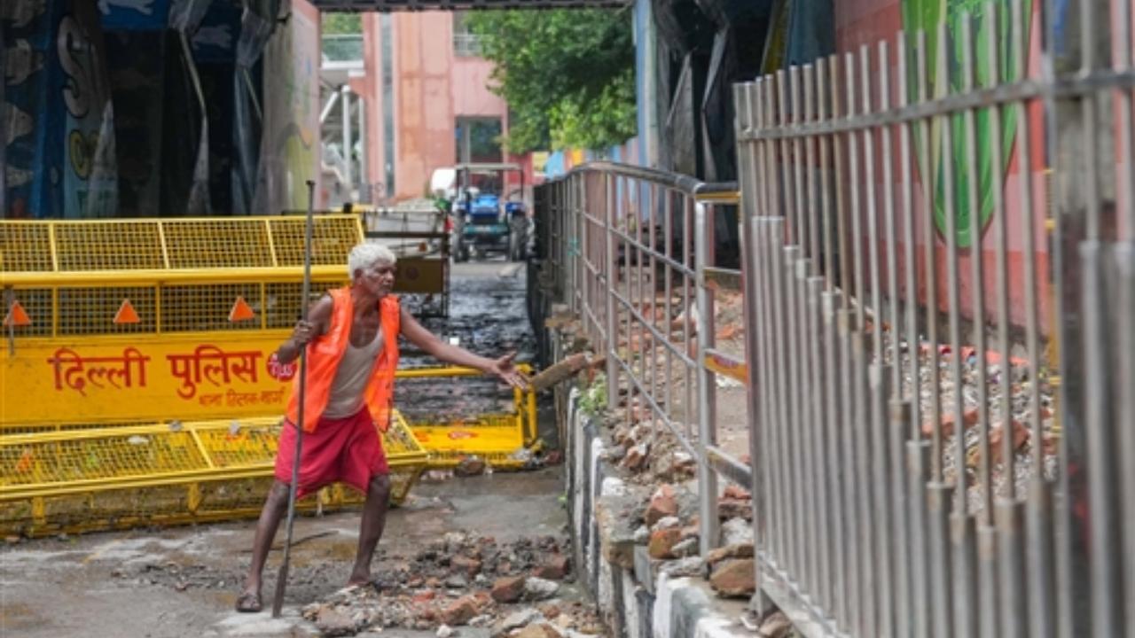A worker repairs a road that got damaged due to monsoon rains, near Tilak Bridge in New Delhi
 