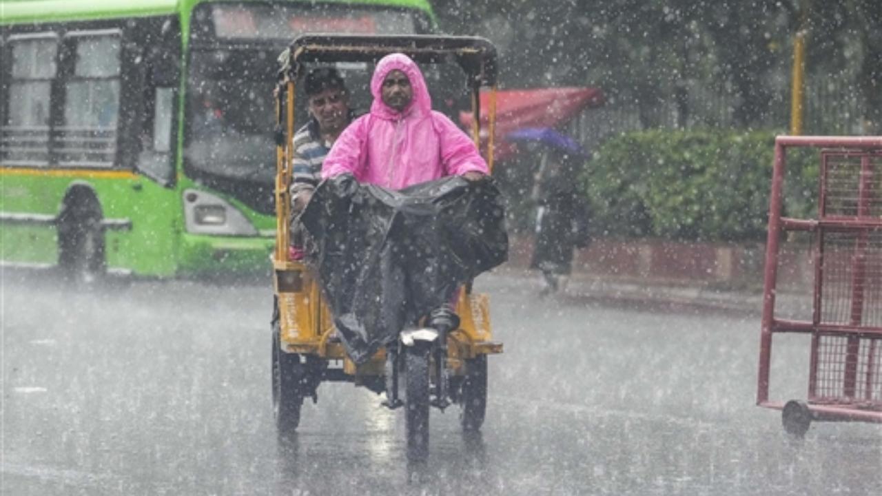 Commuters pass through a road amid heavy monsoon rains, in New Delhi
 
