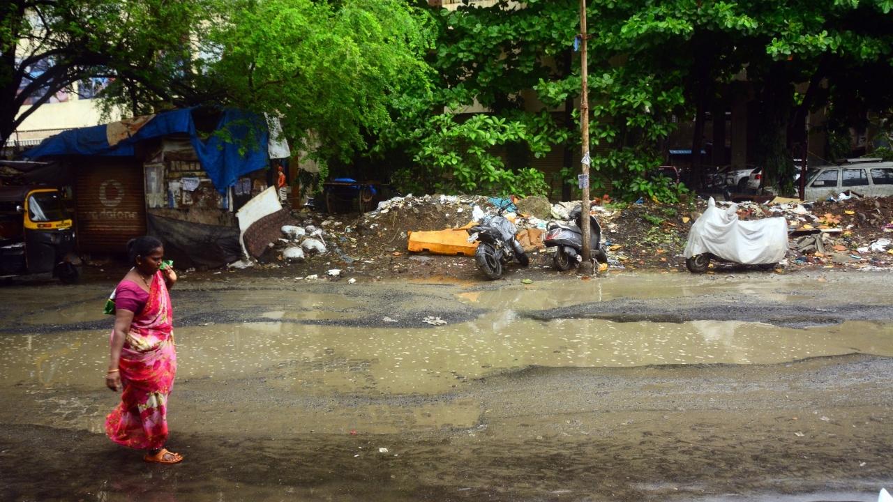 Mumbai continued to witness showers after regular intervals on Sunday. The city has been witnessing heavy rains from past couple of days. Potholes outside the Kurla bus depot were noticed by the passersby. Pic/Satej Shinde