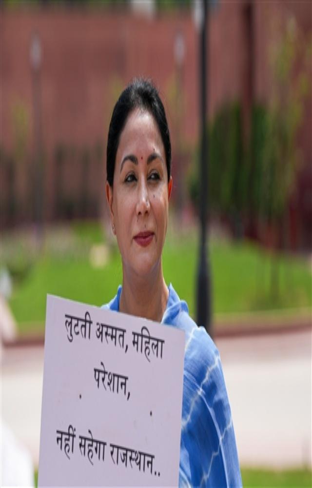 BJP MP Diya Kumari displays a placard while staging a protest at the Gandhi Statue during the the Monsoon session of Parliament, in New Delhi, Friday.