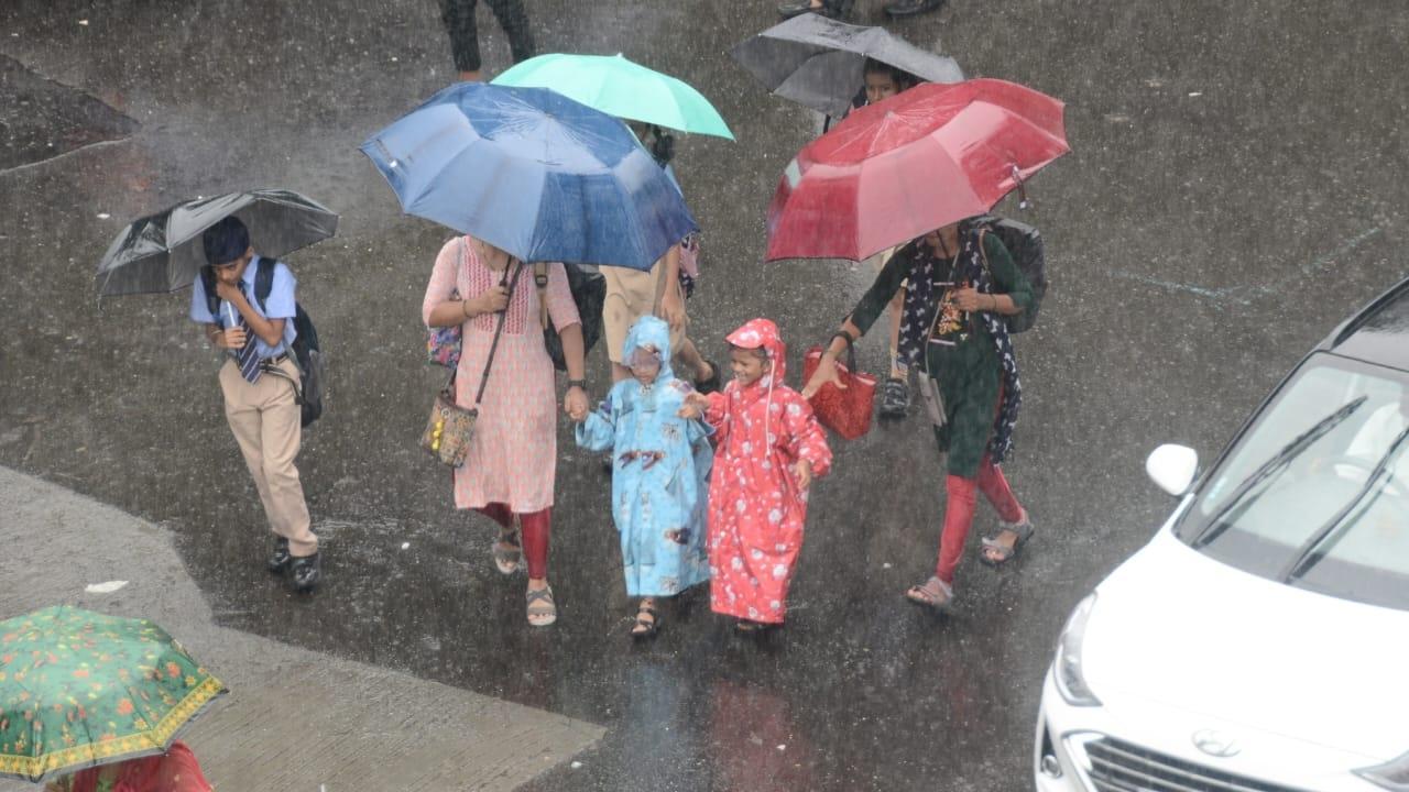 School children walking during showers in city on Thursday. Pics/ Sameer Abedi
