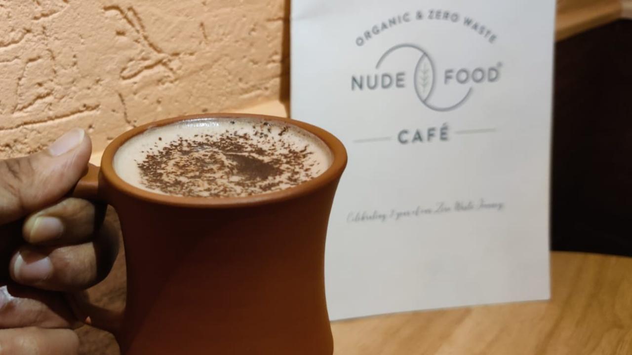 Nude Food Cafe A perfect place for a date and intimate meetings, Nude Food cafe prides itself as an organic, zero-waste and health-conscious eatery. The cafe is a relaxed space brimming with positive vibes. It should be mentioned that the hazelnut hot chocolate ordered by the writer was served to her in an earthen mug that complimented well with the values the cafe propagates. 
Just like the subtle interiors of the cafe, their hot chocolate too was subtle for the taste. A perfectly balanced hazelnut flavour combined with chocolate was an instant hit. What stands this one out from the rest is that it was low on sweetness making it a great option for those who steer clear of more sugar consumption. The cafe serves three kinds of hot chocolate so suit yourself. 