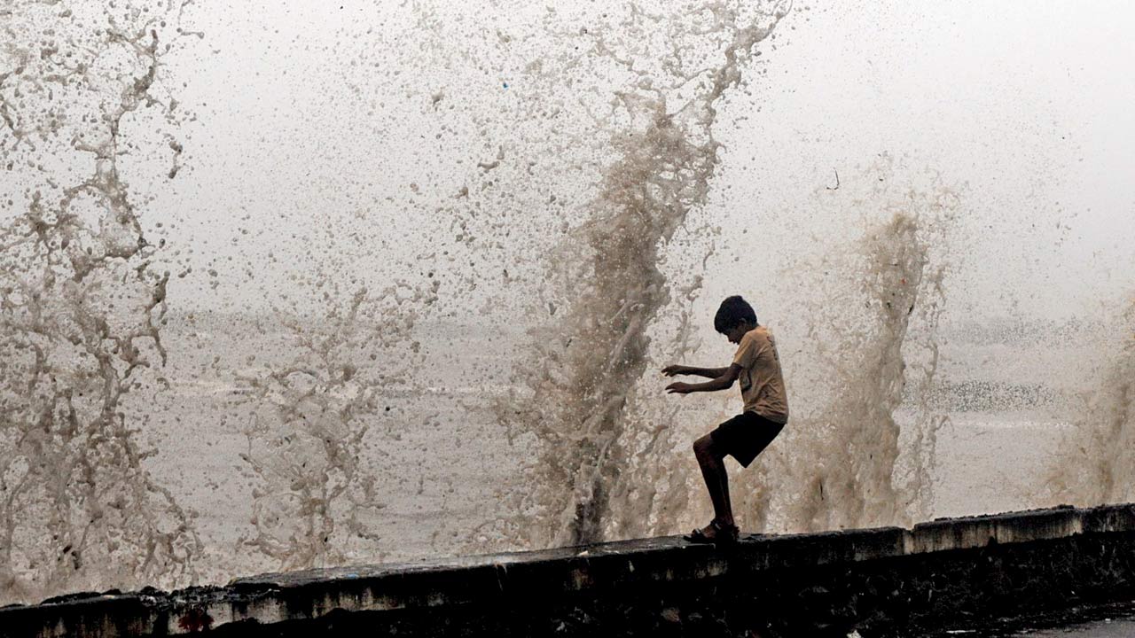 A boy is startled by the huge waves during a high tide at Aksa beach in Malad in 2013. Pic/Nimesh Dave