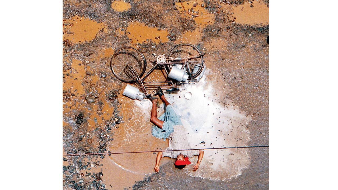 A milkman lies in spilt milk after a tumble near Sher-e-Punjab society on Mahakali Caves road in 2001. Pic/Ashish Rane