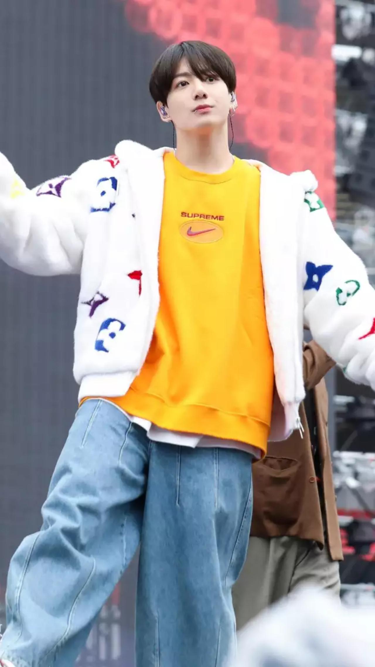 The baggy jeans make a stylish comeback when Jungkook wears them! In a rare moment, JK adds a pop of colour to his stage outfit and looks absolutely adorable in his orange t-shirt, fluffy white sweater and washed jeans
