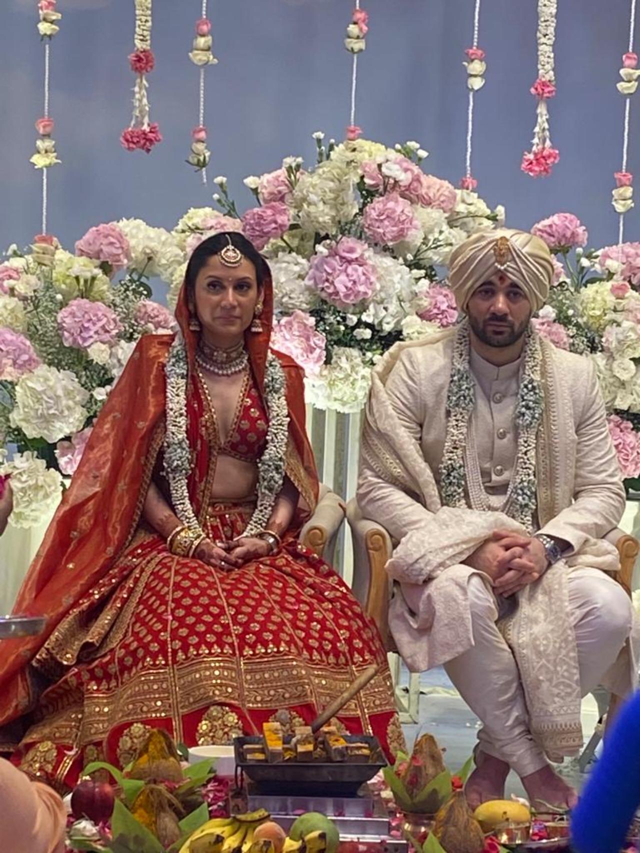 Drisha is beautifully styled in  a royal red ensemble of lehenga choli, ghungat and jewellery. The couple sat amidst a traditional puja assemblage flanked by videographers and family members. The hall was artistically decorated in floral arrangements of blush pink, white and silver (Pic Credits: Pallav Paliwal)