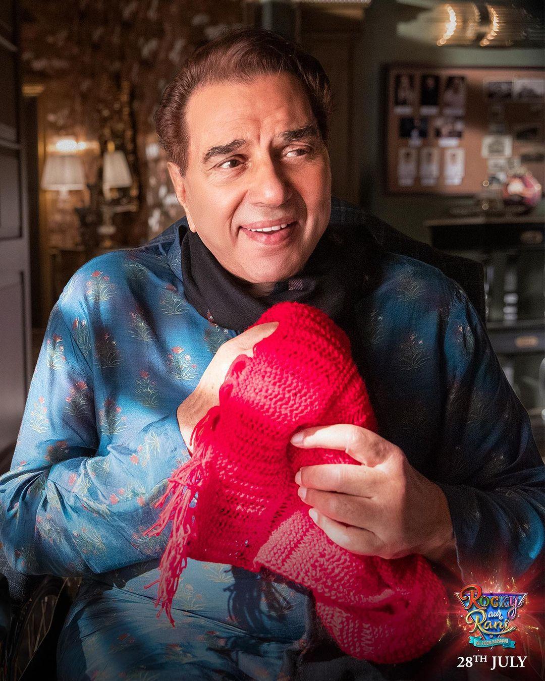 Dharmendra, who will be seen on screen after a long time, is also seen clutching a red scarf in the new still, adding to the intrigue