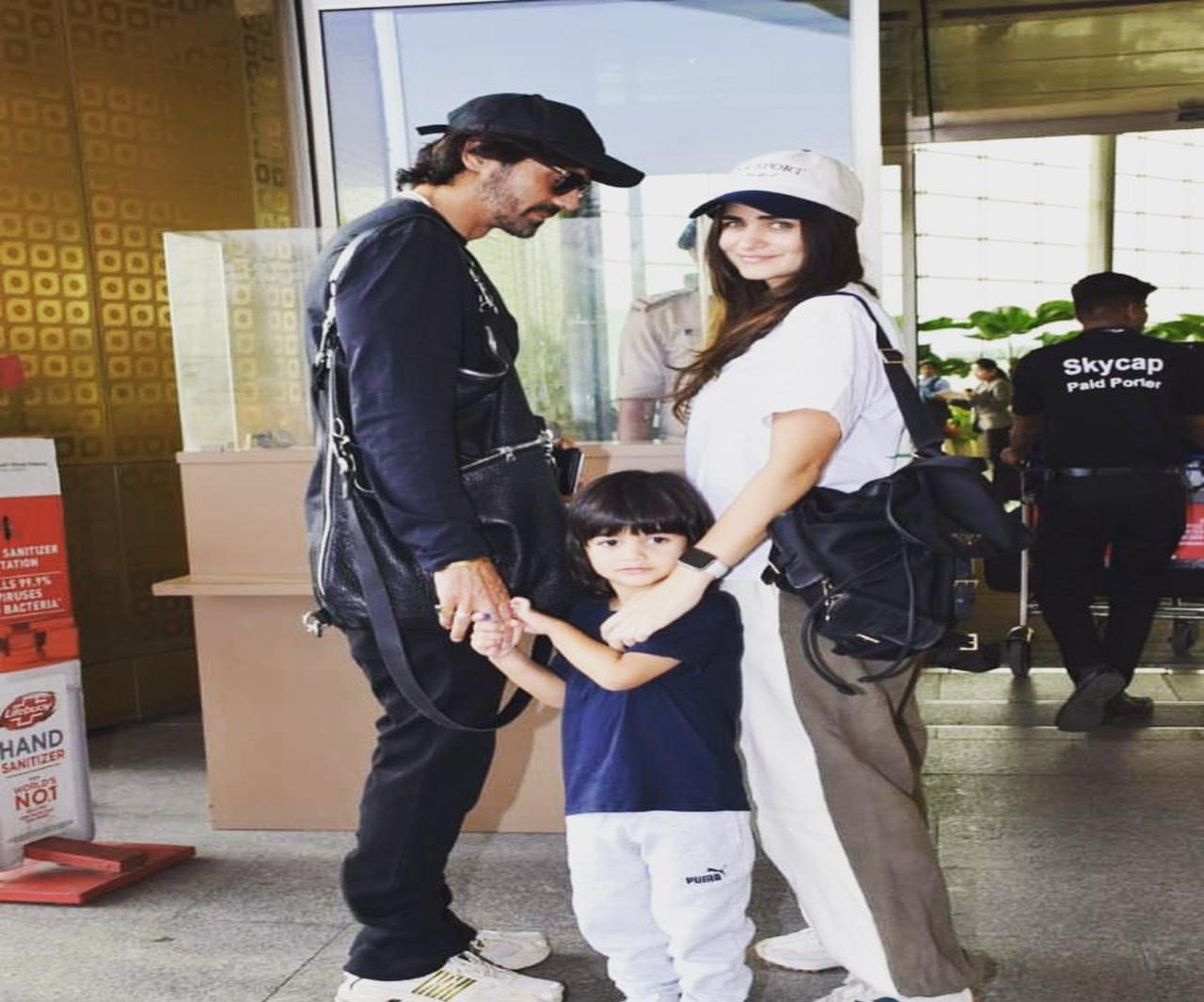 Arjun and his girlfriend pose with little Arik dressed in sailor coloured blue and white at the airport