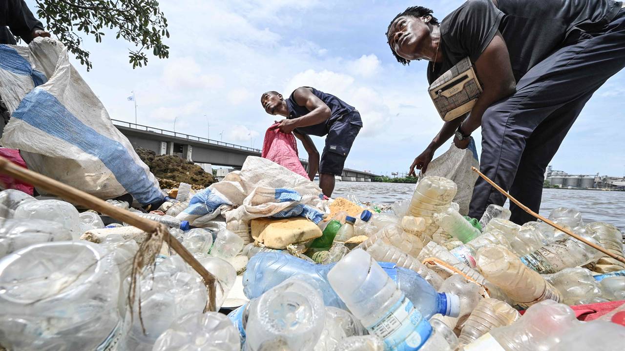 Residents collect plastics bottles and bags in the Ebrie Lagoon in Abidjan on May 31, 2023 ahead of World environnement Day celebrations. The United Nations Environment Program (UNEP) estimates that 400 million tonnes of plastic are produced worldwide each year, half of which is designed for single use. Pic/AFP