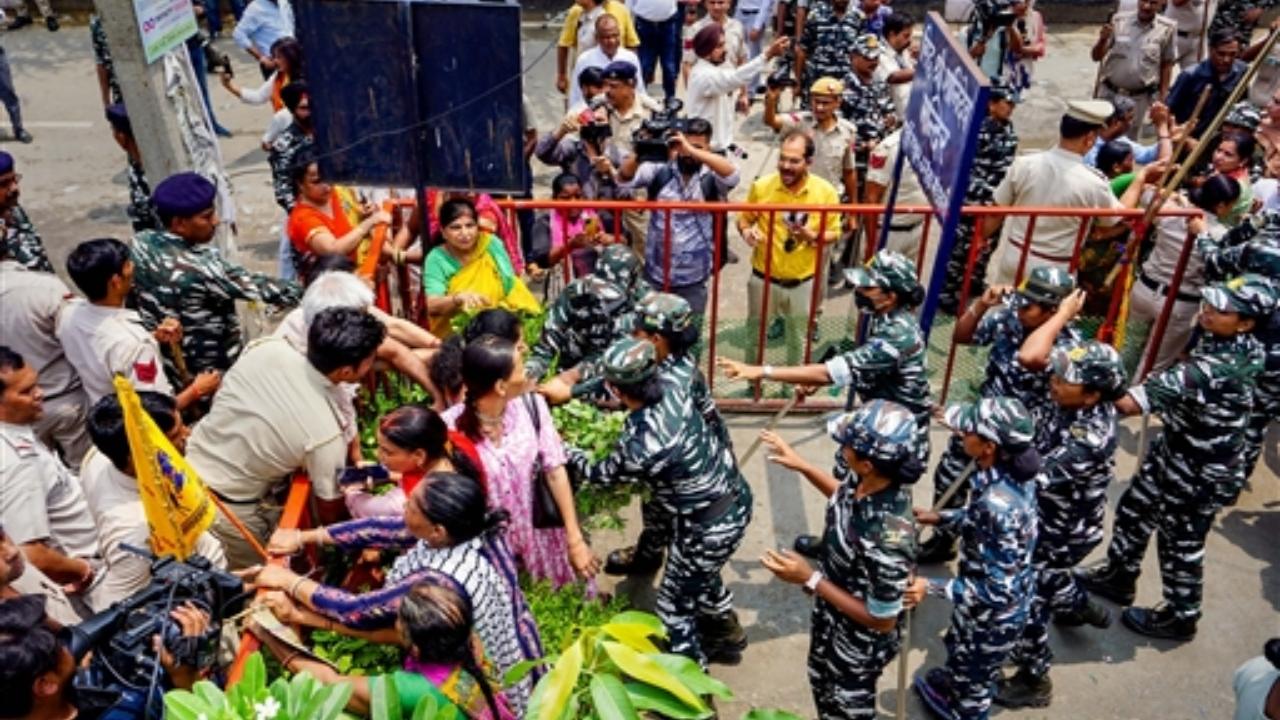 Security personnel speak with locals protesting against the removal of a portion of a temple in Mandawali area
 