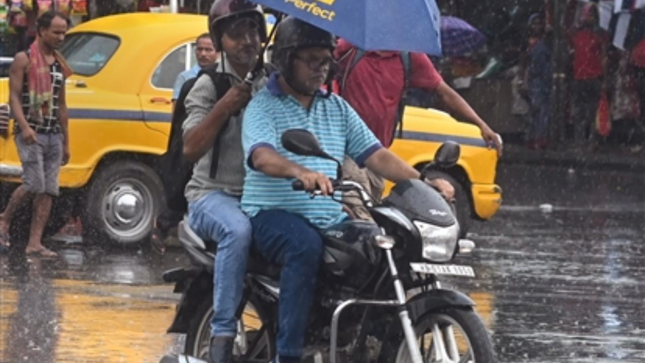 The DM said that one was killed in Old Malda, while the remaining six people lost their lives in the Kaliachak area
In Pic: Commuters ride a two-wheeler amid rainfall, in Kolkata
 