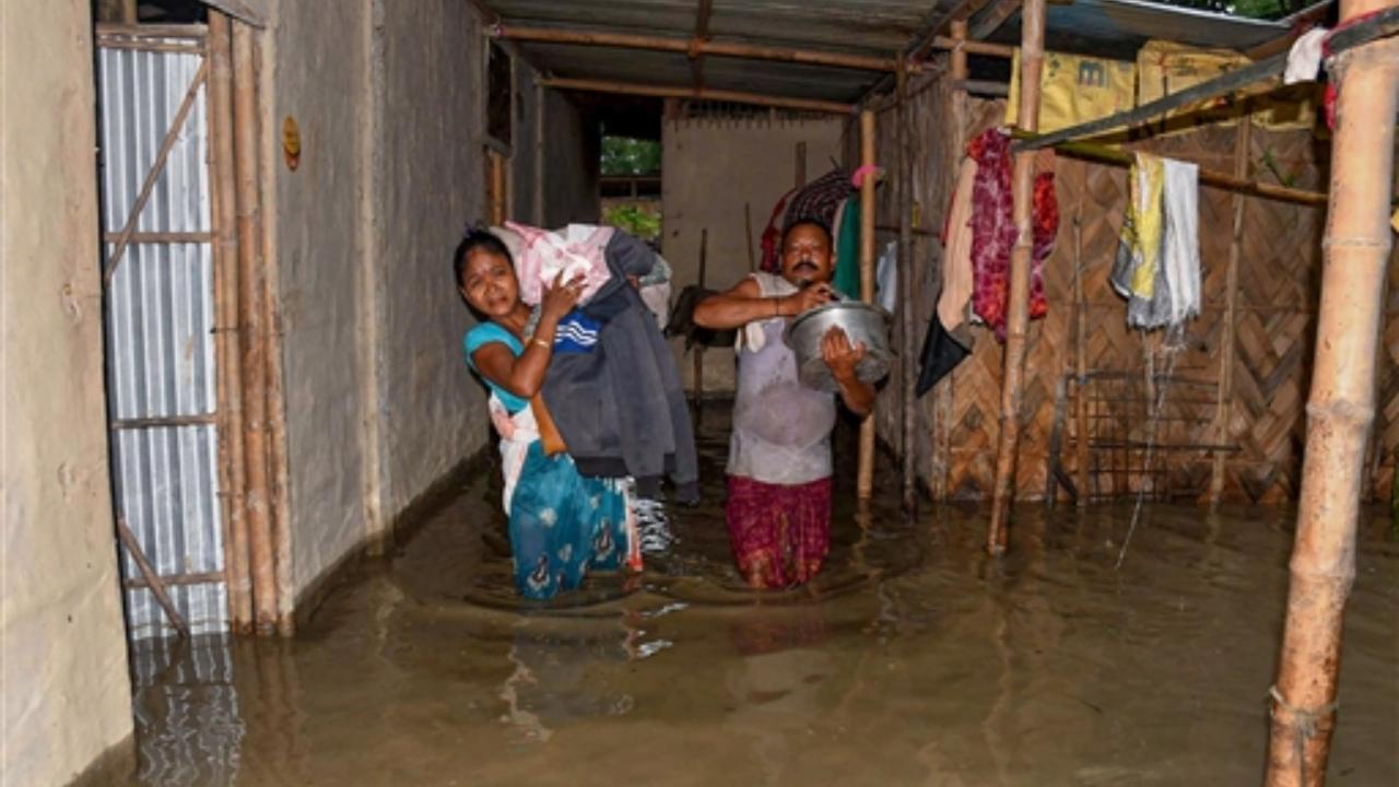 A family shifts from a flooded village in Baska district of Assam (Pic/PTI)