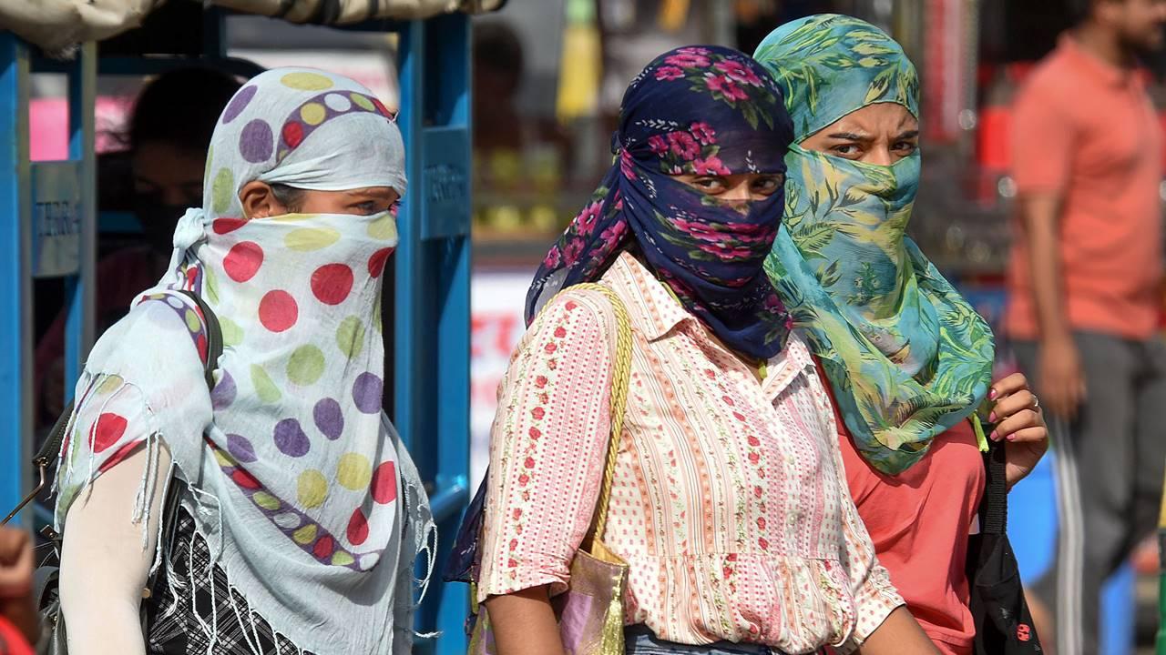 Women use scarves for protection from scorching weather on a hot summer day, in Patna.