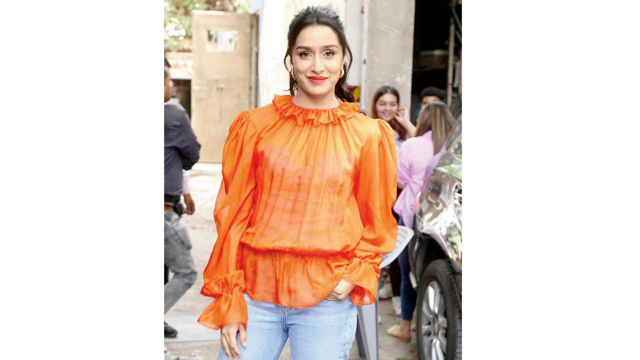 Shraddha Kapoor in a simple neon orange top with ruffle details around the neck