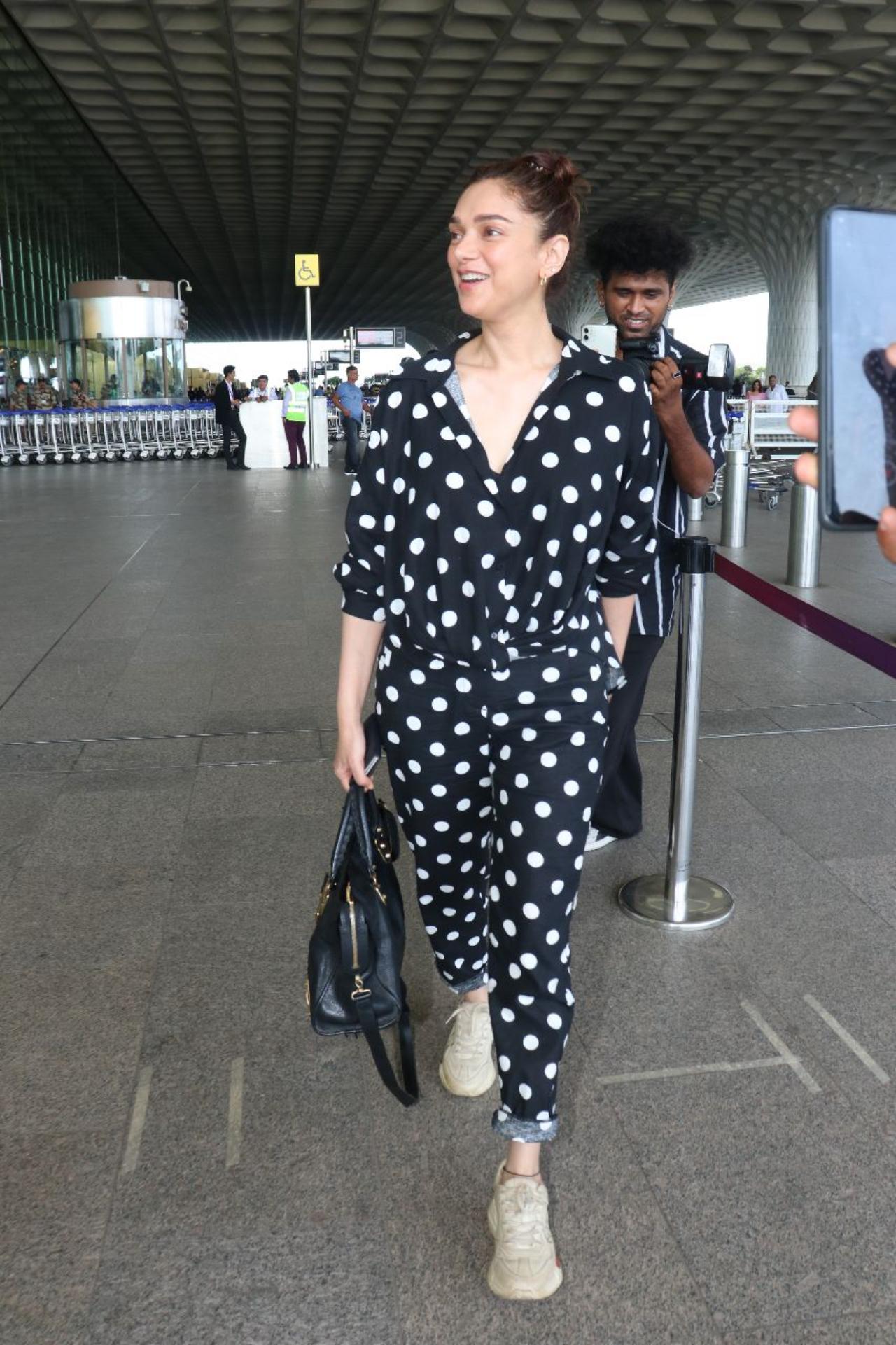 Aditi Rao Hydari was spotted at the Mumbai airport on Friday morning. She was all smiles as she walked towards the entrance of the airport and greeted the paparazzi present there