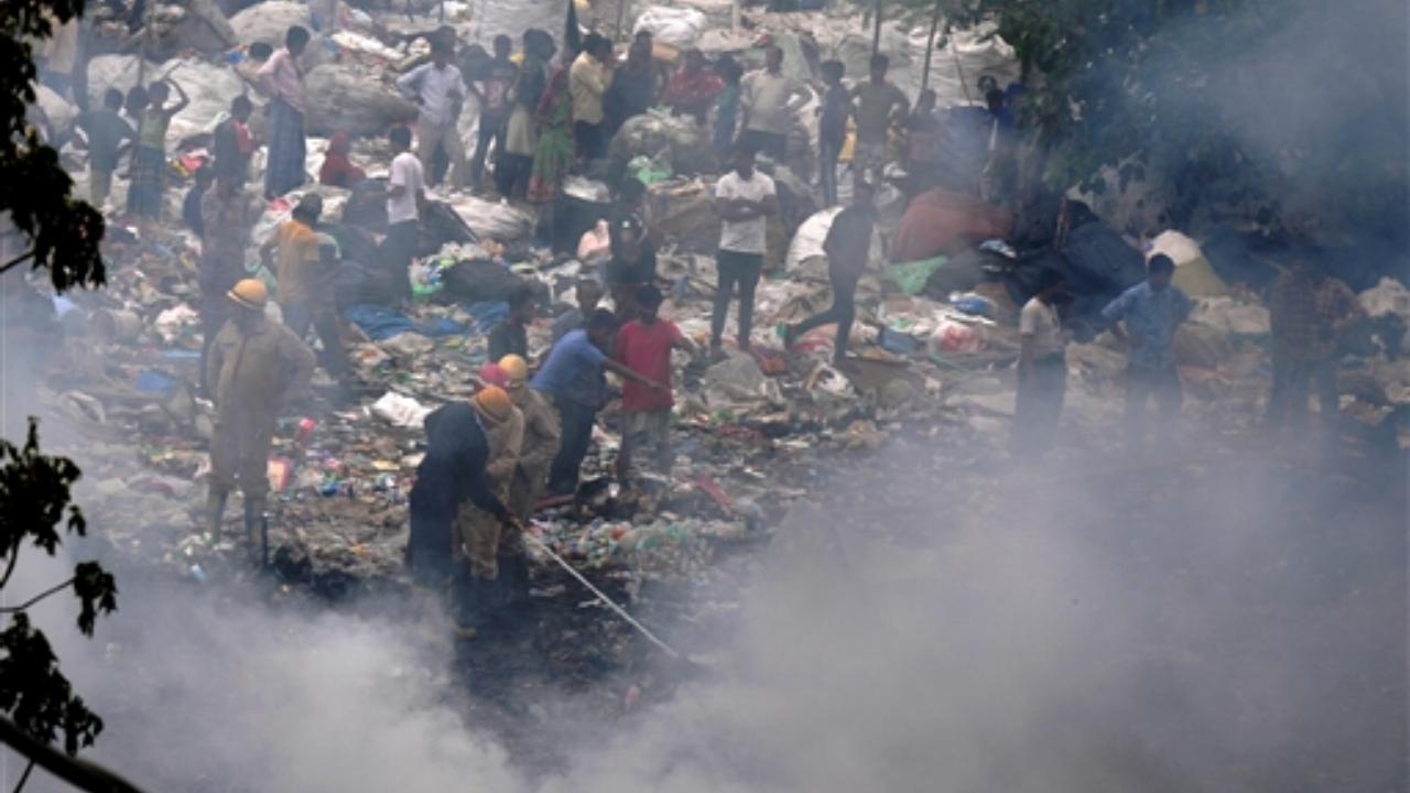 Fire men douse a fire which broke out in an open area at a slum in Jahangirpuri (Pic/PTI)