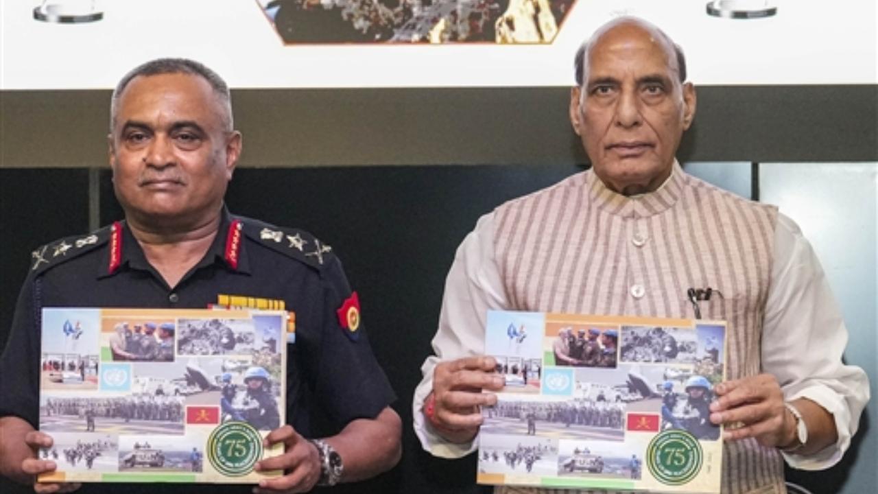 Defence Minister Rajnath Singh and Chief of Army Staff General Manoj Pande show 'photo albums' of Indian Army's role during the 75 years of UN Peacekeeping at the 75th anniversary event of ‘UN Peacekeepers Day’