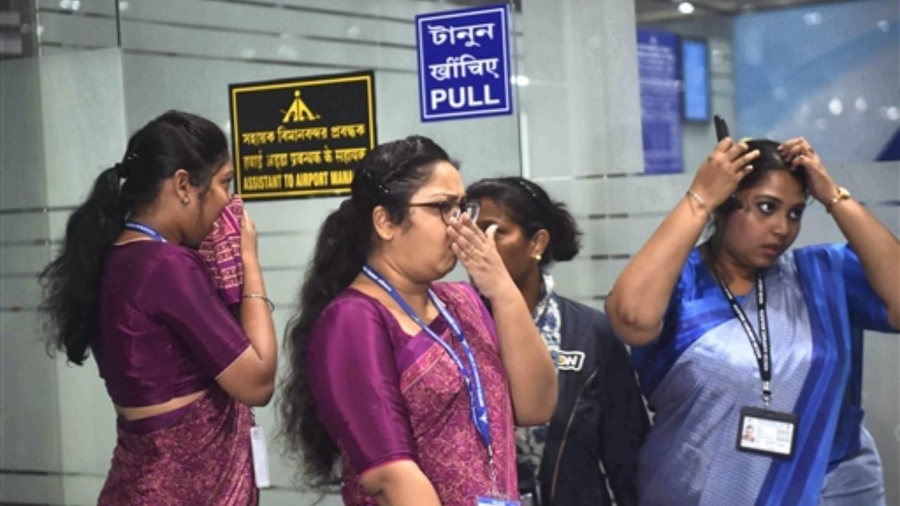 Airport officials react after a fire broke out at the departure gate of Netaji Subhash Chandra Bose International Airport, in Kolkata