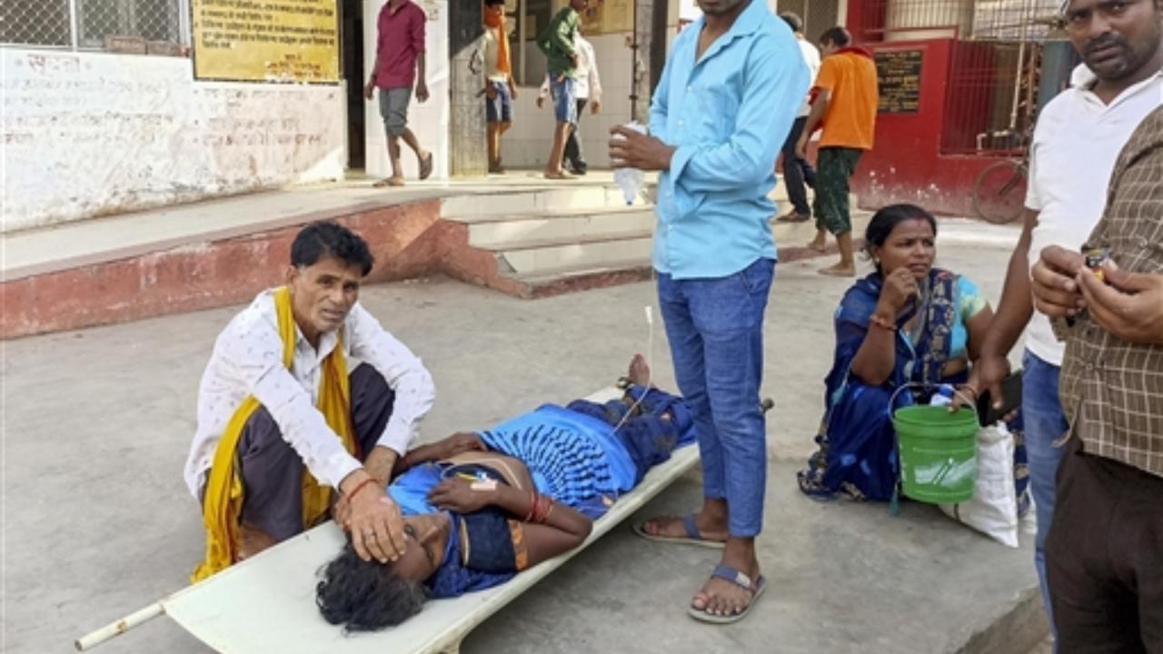 Family members with their patient admitted at a hospital due to heatwave conditions, in Ballia