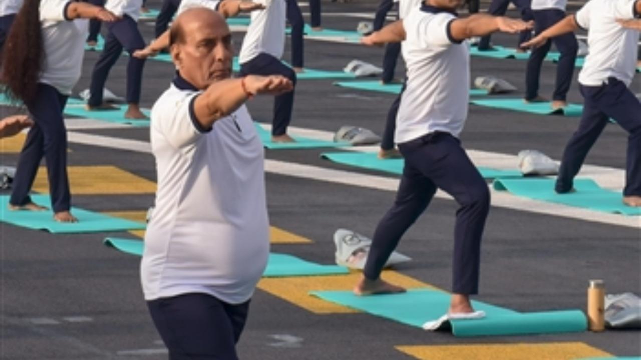 Defence Minister Rajnath Singh with others performs yoga on the International Day of Yoga onboard INS Vikrant, in Kochi
 
