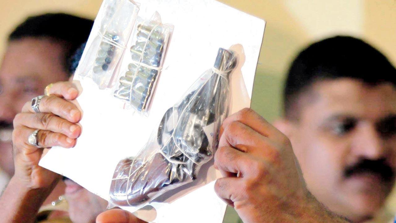 A file photo dated June 27, 2011 of the police holding up the gun used by the shooters to shoot Jyotirmoy Dey during a press conference. Pic/Getty Images