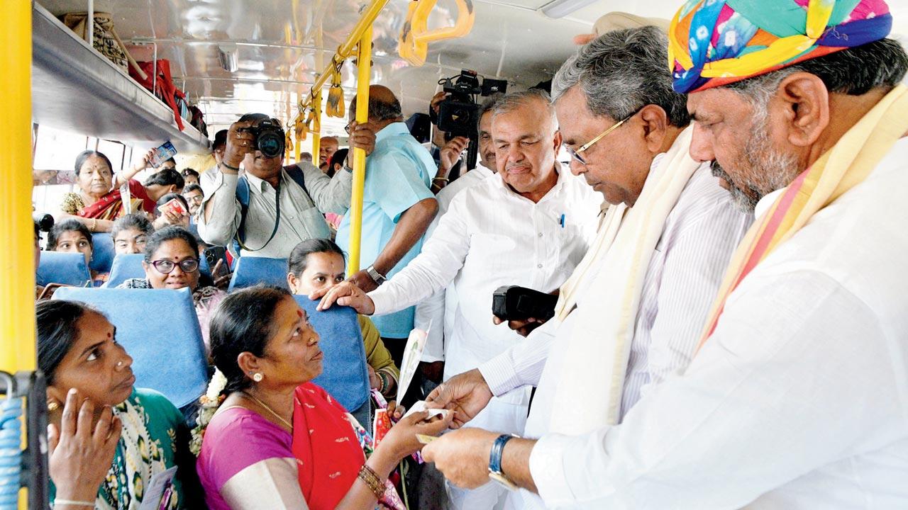 Some of the first beneficiaries of the scheme interact with the CM and the deputy CM, in Bengaluru, on Sunday. Pic/PTI 