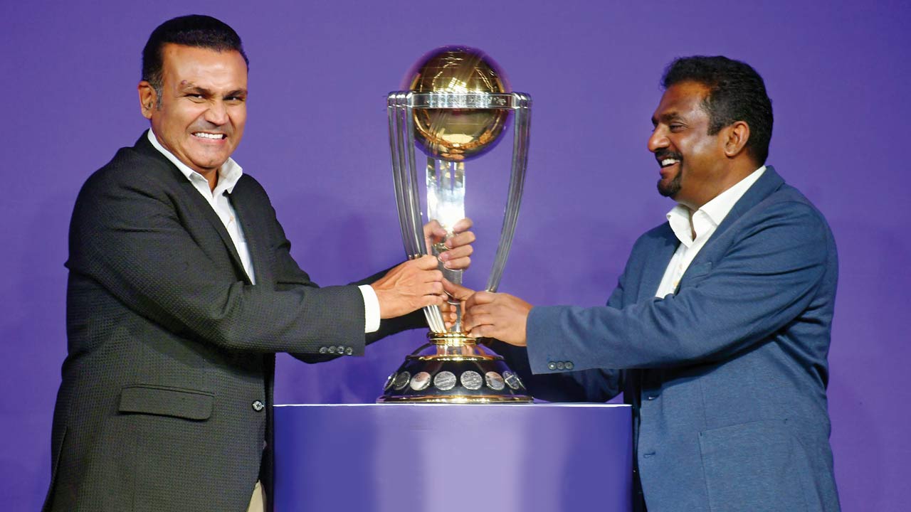 Former cricketers Virender Sehwag (left) and Muttiah Muralidaran with the  ICC ODI World Cup trophy in Mumbai yesterday.  Pic/Ashish Raje