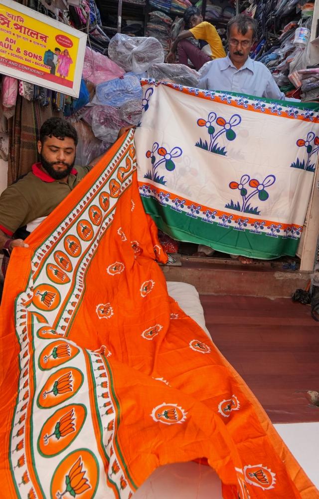 Shopkeepers showcase sarees with symbols of different political parties