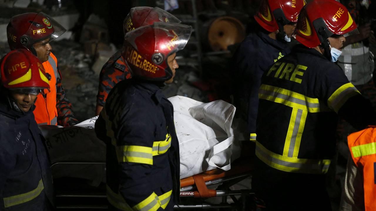 Firefighters carry a recovered dead body. Pic/AFP