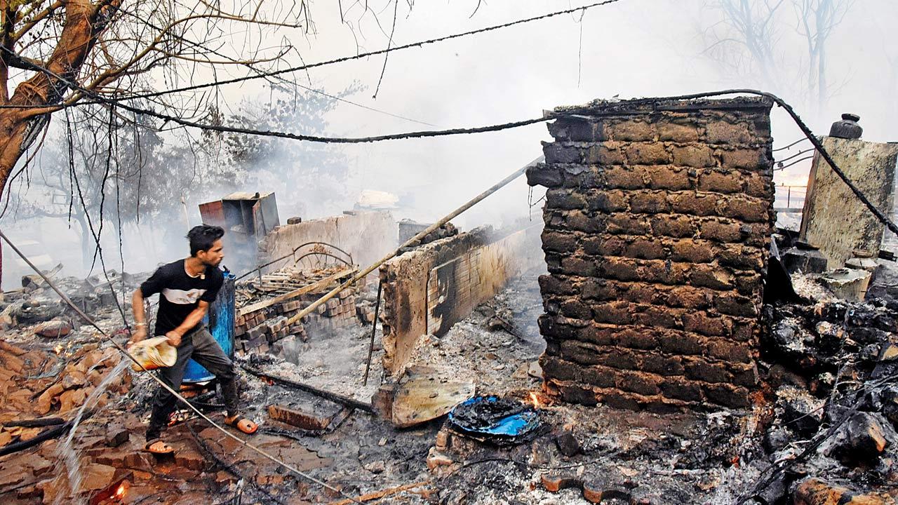 A man tries to douse the fire at Anand Nagar slum in Appa pada, Malad East, on Monday 