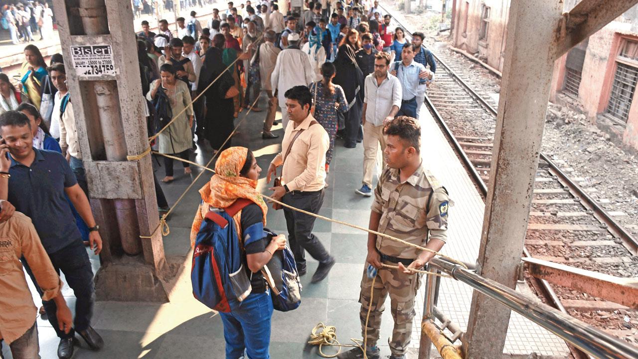 A GRP jawan stops a passenger from crossing the blockade, on platform No. 1 of Dadar railway station, on Thursday. Pic/Ashish Raje