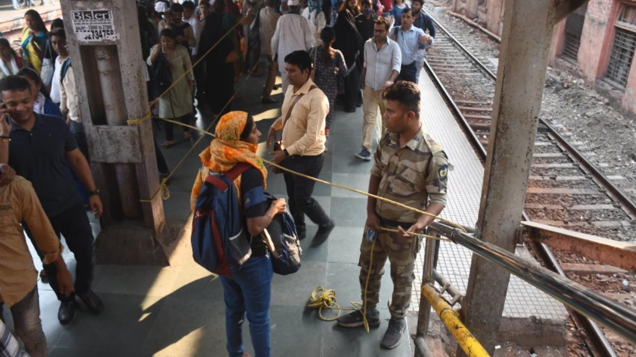 A GRP jawan stops a passenger from crossing the blockade, on platform No. 1 of Dadar railway station