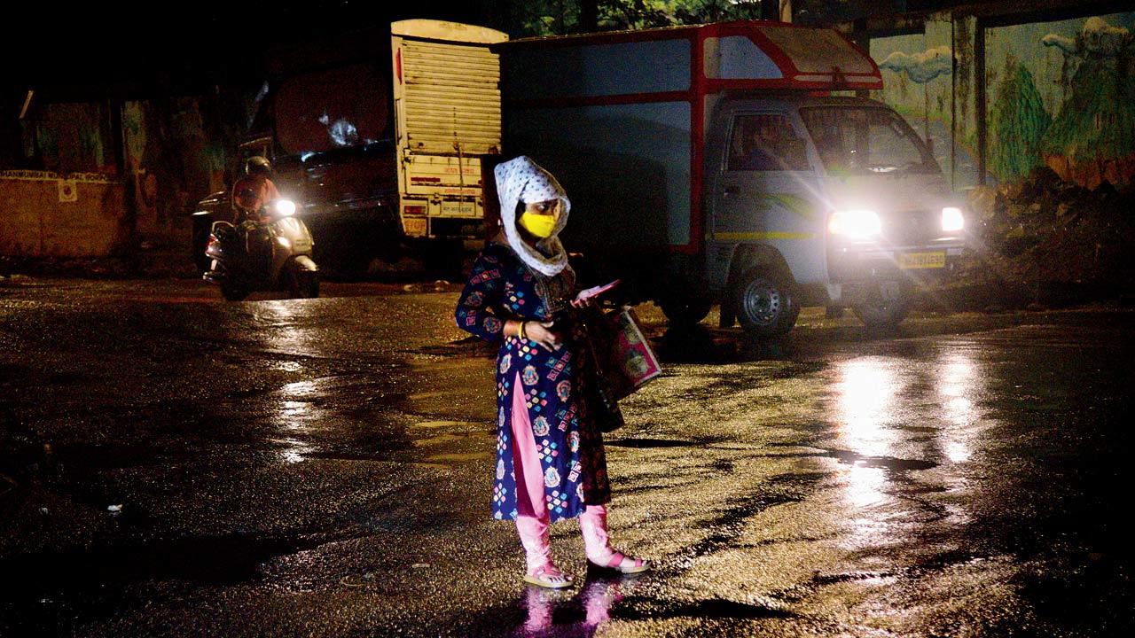 A woman caught in an unexpected heavy shower at Sion on Thursday night. Pic/Pradeep Dhivar