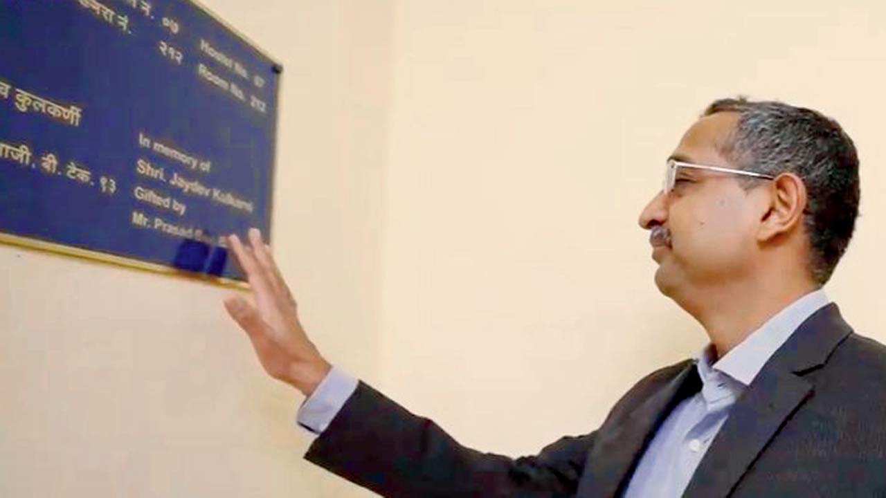 Prasad Baji touches the plaque post naming of a hostel room after his grandparents