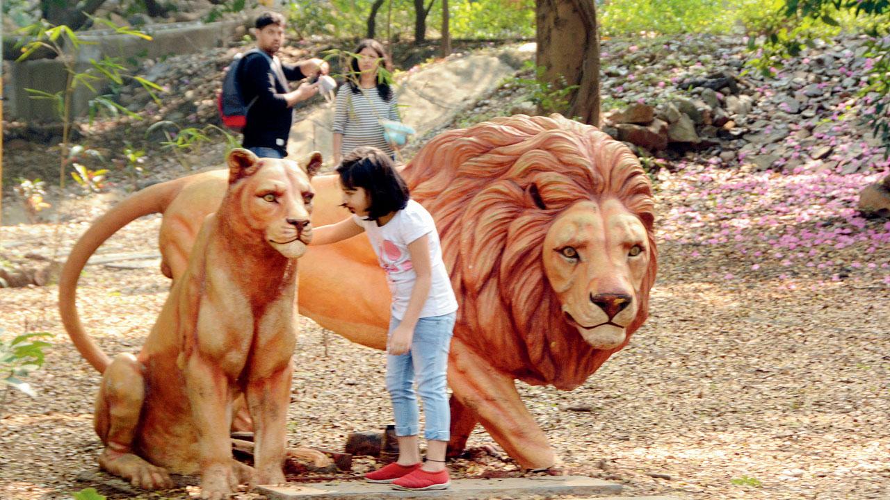 A kid pets replicas of characters from The Lion King at SGNP